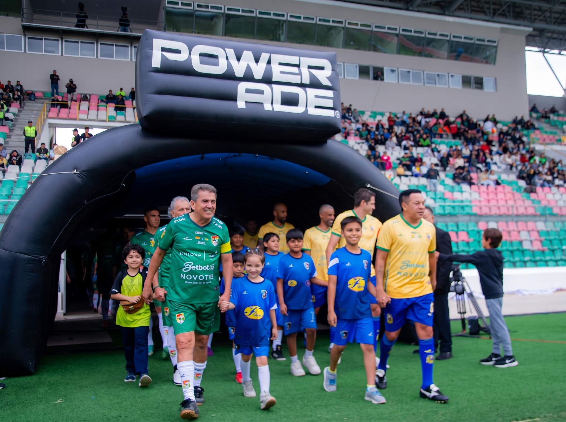 Lendas do futebol entrando em campo ao lado de uma nova geração