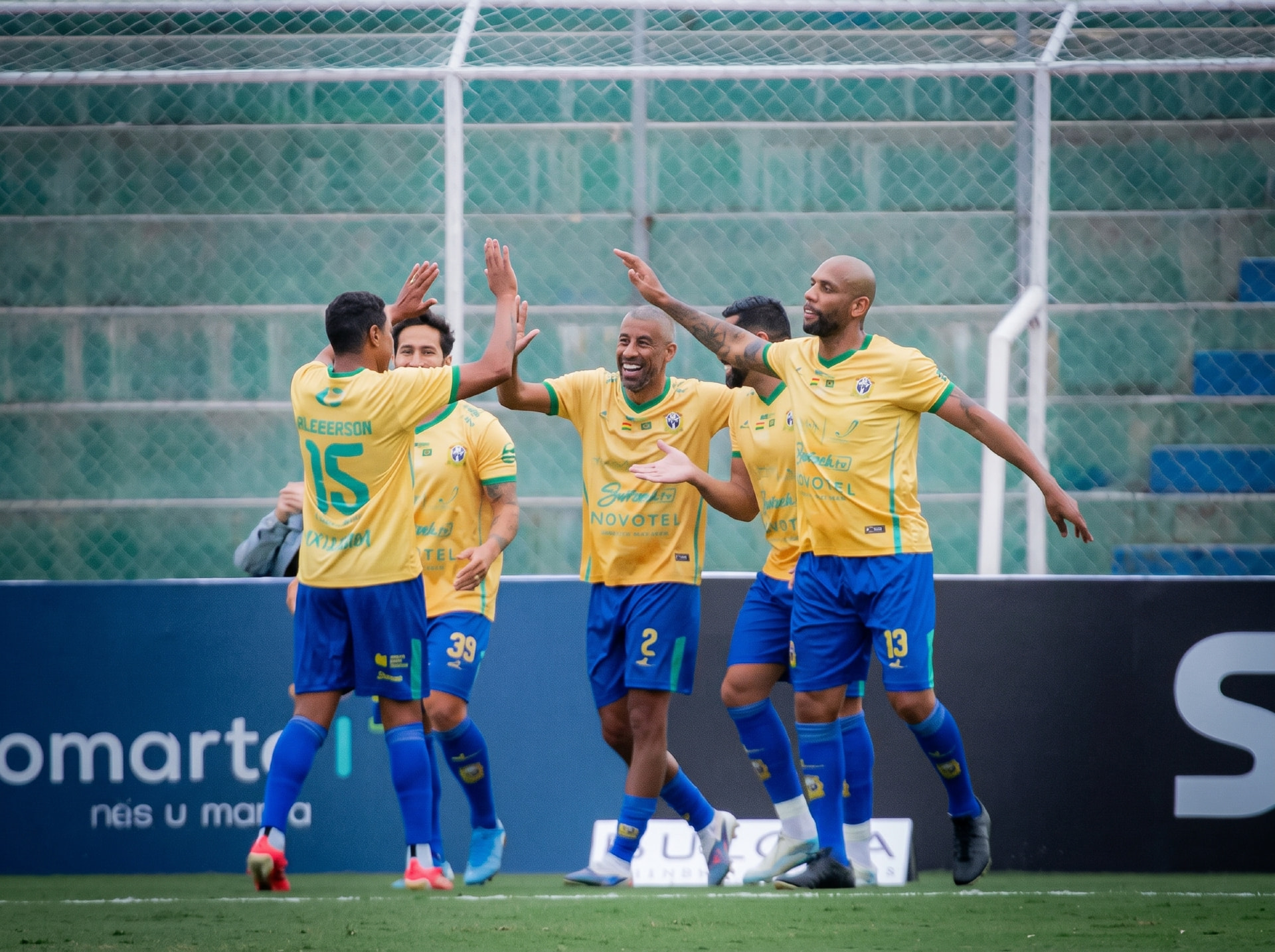 Lendas do futebol celebrando juntas em campo